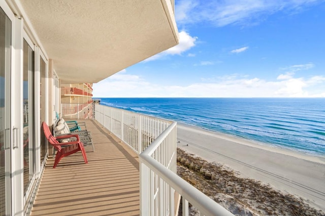 balcony with a water view and a beach view