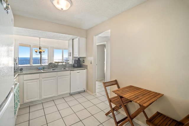 kitchen featuring dishwasher, a water view, white cabinetry, and sink