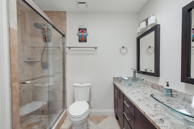 bathroom featuring vanity, a shower with shower door, toilet, and tile patterned flooring