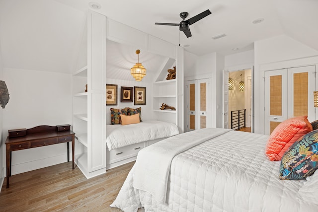 bedroom with hardwood / wood-style floors, ceiling fan, and vaulted ceiling