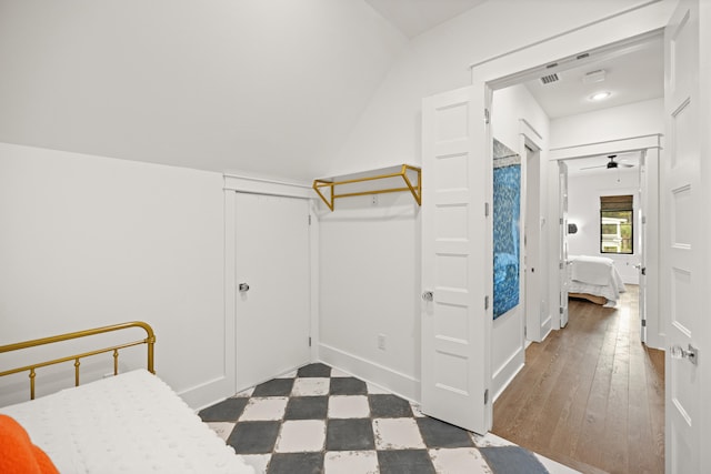 bedroom with a closet, dark wood-type flooring, and lofted ceiling