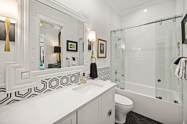 full bathroom with toilet, vanity, bath / shower combo with glass door, and ornamental molding