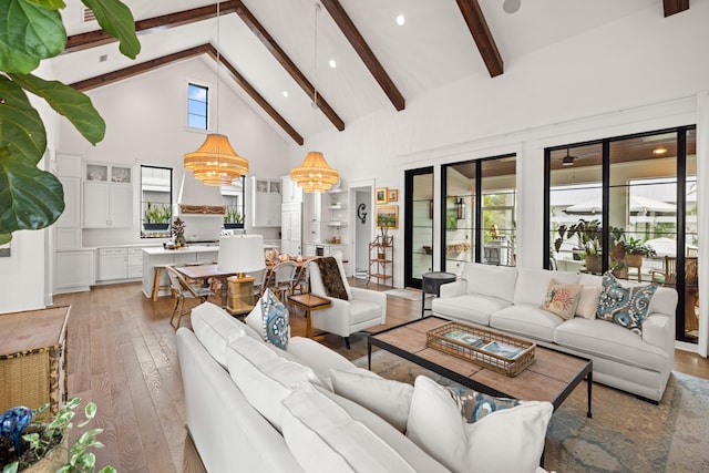 living room featuring beamed ceiling, an inviting chandelier, hardwood / wood-style flooring, and high vaulted ceiling