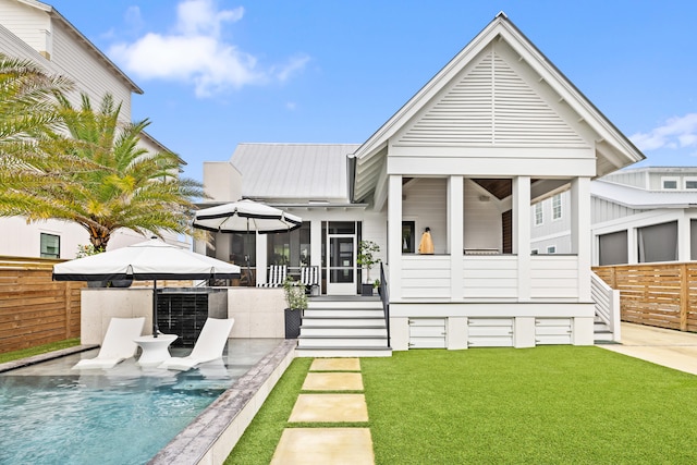 back of property with a sunroom, a yard, and a patio