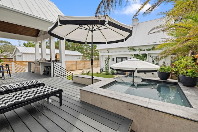 deck with a jacuzzi, area for grilling, and exterior kitchen