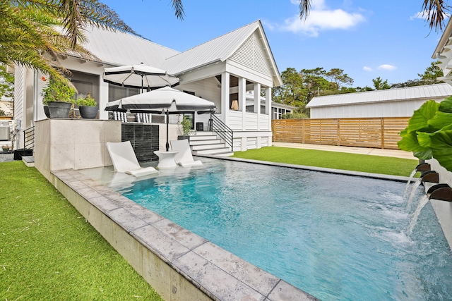 view of swimming pool featuring pool water feature and a yard