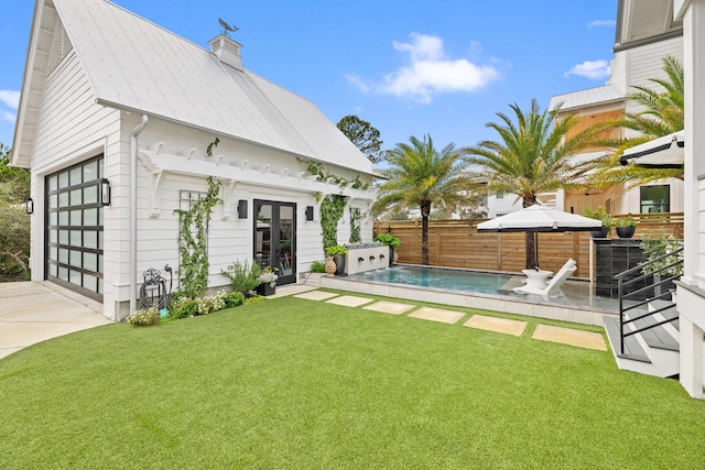 back of house featuring a lawn, french doors, an outdoor structure, and a fenced in pool