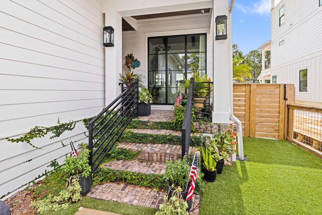 doorway to property with a lawn