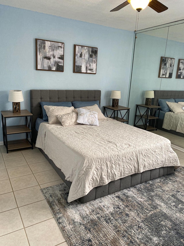 bedroom with a closet, a ceiling fan, and tile patterned floors