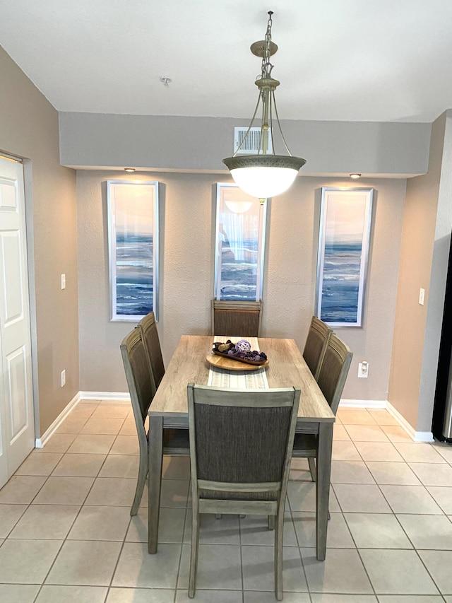 dining space featuring baseboards and light tile patterned floors