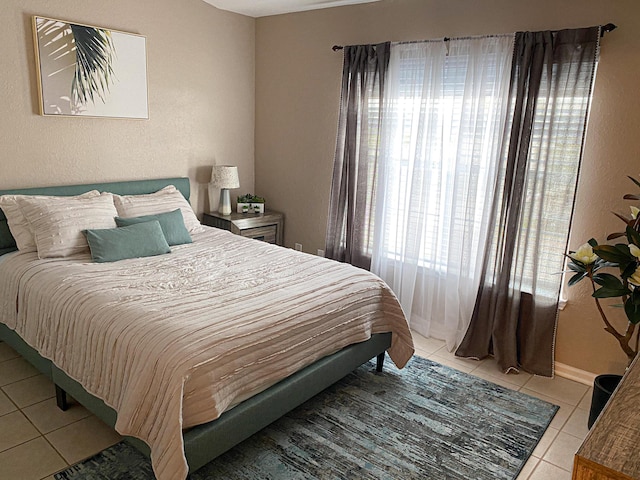 bedroom featuring light tile patterned floors and baseboards