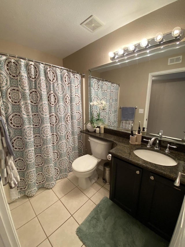 bathroom featuring toilet, tile patterned flooring, visible vents, and a textured ceiling