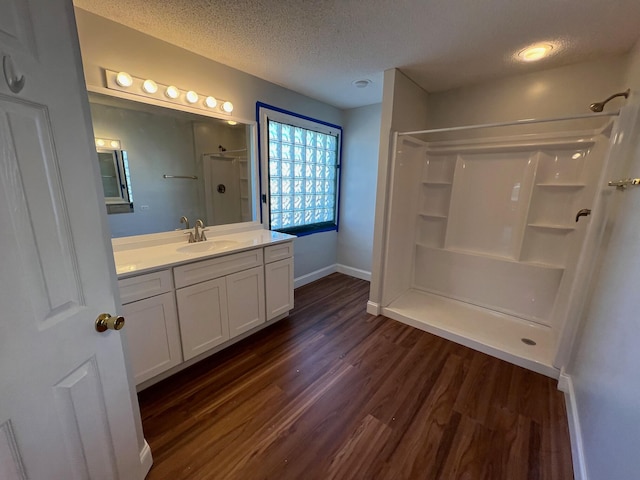 bathroom featuring a shower, vanity, a textured ceiling, and hardwood / wood-style flooring