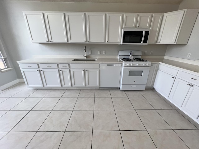 kitchen with sink, white appliances, white cabinets, and light tile patterned flooring