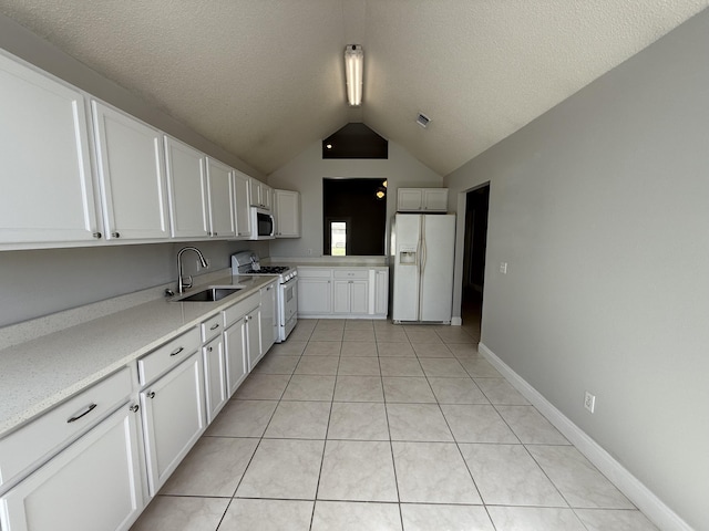 kitchen with a sink, white appliances, light countertops, white cabinetry, and lofted ceiling