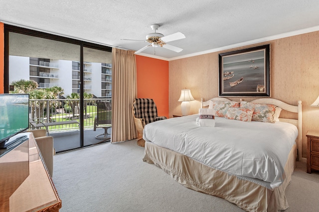 carpeted bedroom with ceiling fan, access to outside, a textured ceiling, and ornamental molding