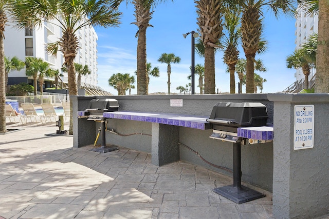 view of patio / terrace with area for grilling and a swimming pool