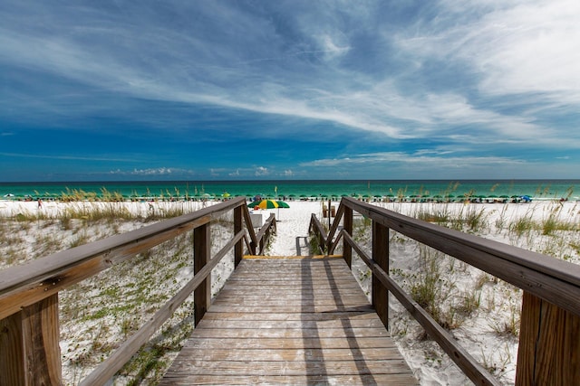 view of property's community featuring a water view and a beach view