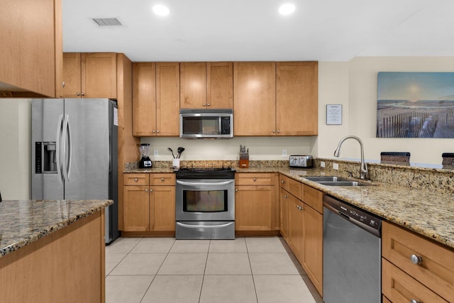 kitchen featuring light tile patterned floors, stainless steel appliances, light stone countertops, and sink