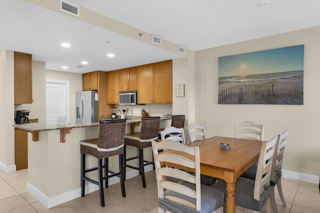 dining area featuring sink and light tile patterned floors