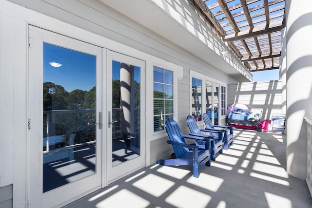 balcony featuring french doors, a patio area, and a pergola