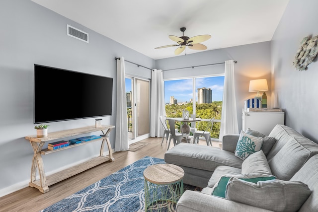 living room with light hardwood / wood-style flooring and ceiling fan