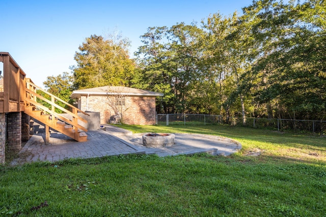 view of yard featuring stairway, a fenced backyard, a fire pit, and a patio