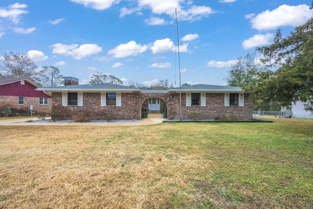 single story home with brick siding, a chimney, and a front lawn