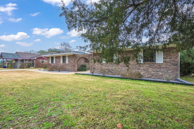 single story home featuring brick siding and a front yard