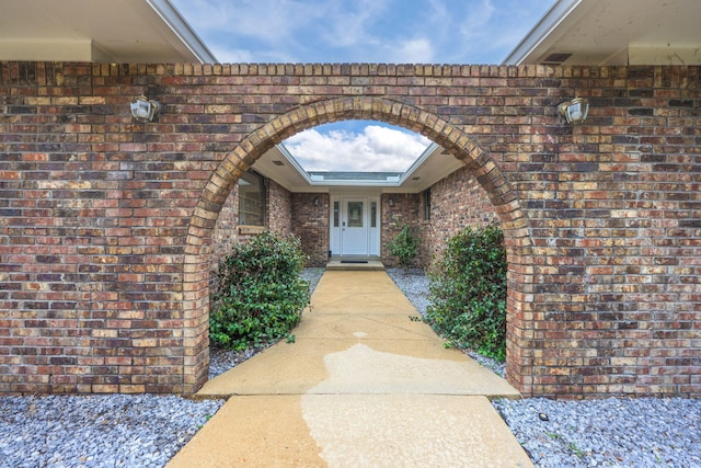 entrance to property featuring brick siding