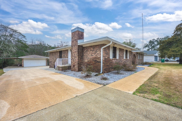 view of front of home featuring a garage, brick siding, an outdoor structure, and a chimney