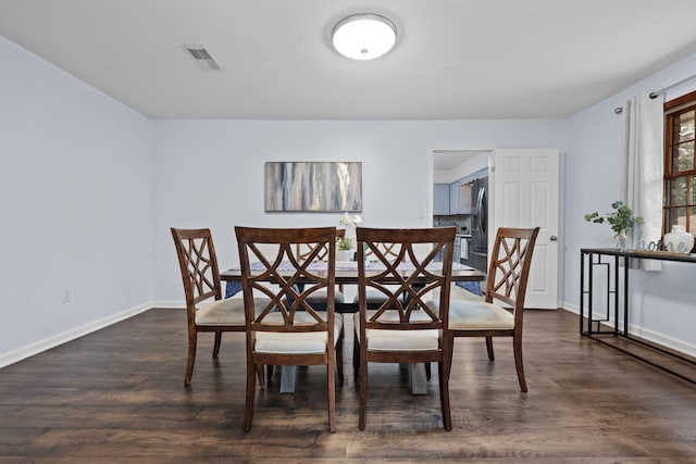 dining area featuring dark wood finished floors, visible vents, and baseboards