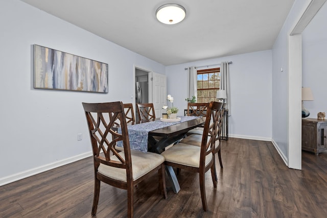 dining space featuring baseboards and dark wood-type flooring