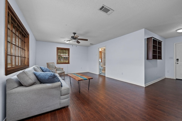 living room with ceiling fan, dark wood finished floors, visible vents, and baseboards