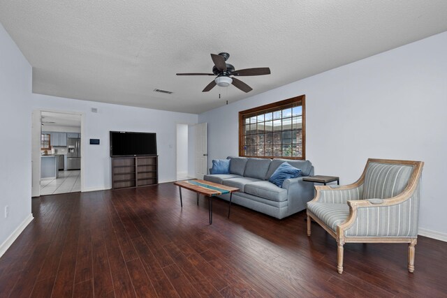 living area with ceiling fan, a textured ceiling, wood-type flooring, and visible vents