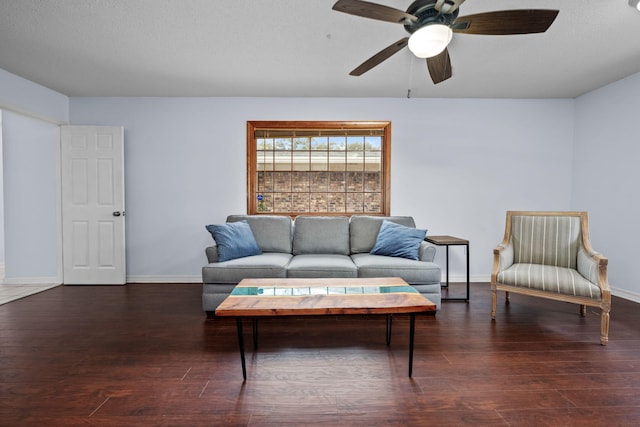 living area with a ceiling fan, a textured ceiling, baseboards, and dark wood-style flooring