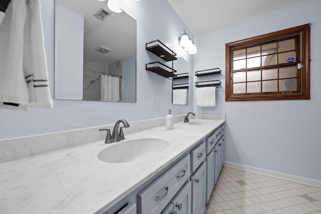 bathroom featuring double vanity, a sink, visible vents, and baseboards