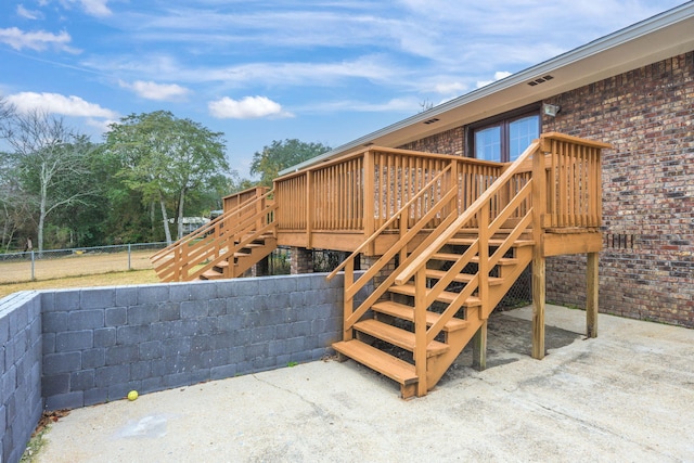 exterior space featuring stairs, a deck, and fence