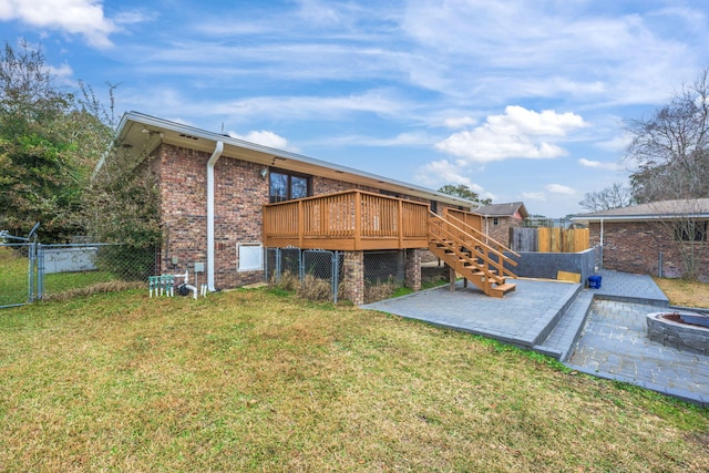 rear view of house featuring an outdoor fire pit, stairs, fence, a wooden deck, and brick siding