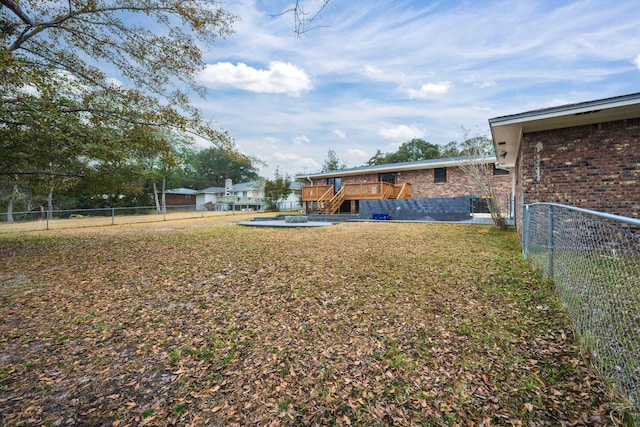 view of yard with a fenced backyard, stairs, and a deck