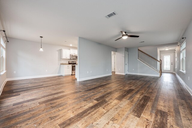 unfurnished living room with dark wood-type flooring and ceiling fan