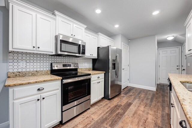 kitchen featuring appliances with stainless steel finishes, light stone countertops, and white cabinets