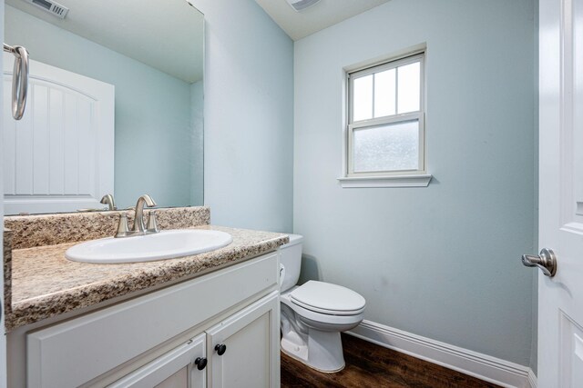 bathroom featuring hardwood / wood-style flooring, vanity, and toilet