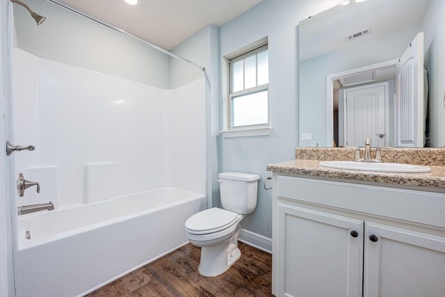 full bathroom with vanity, tub / shower combination, hardwood / wood-style floors, and toilet