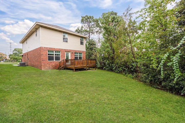 rear view of house featuring central AC unit, a lawn, and a deck