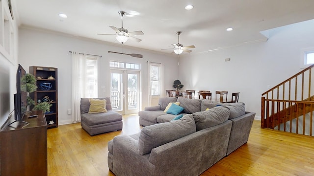 living room with ceiling fan, ornamental molding, and light hardwood / wood-style flooring