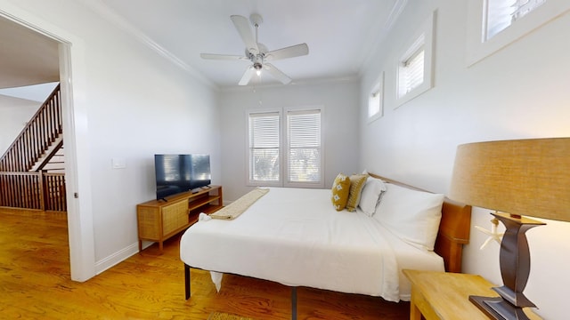 bedroom with ornamental molding, hardwood / wood-style floors, and ceiling fan