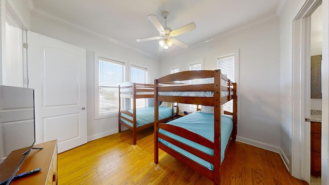 bedroom featuring ceiling fan, crown molding, and wood-type flooring