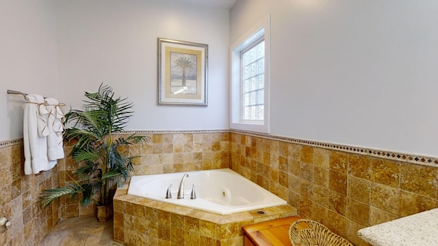 bathroom featuring a relaxing tiled tub and tile walls