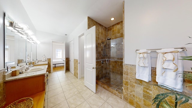 bathroom with vanity, a shower with shower door, tile patterned floors, and tile walls